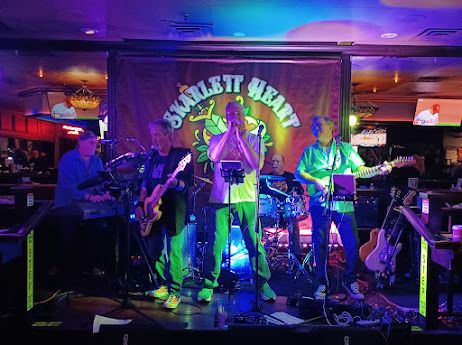 Live band performing on stage with vibrant lighting.