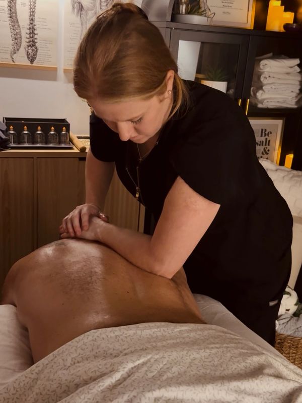 Therapist giving a deep tissue massage to a client in a cozy clinic.