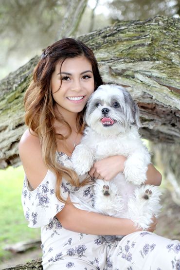 Sweet High School Senior photo of a girl holding her dog in the woods, Light and airy.
