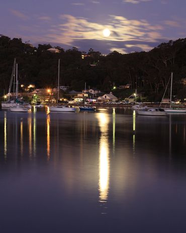 photo of bay at night with reflections on the water