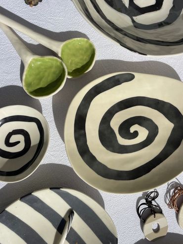 black and white ceramic bowls and green ceramic spoons