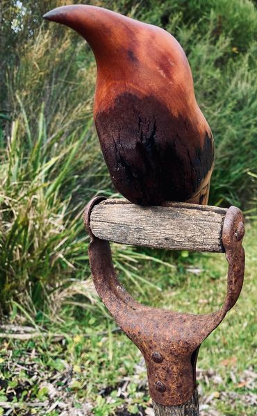 wood sculpture of bird sitting on spade handle