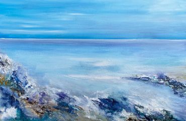 Calm ocean with rocky shore under blue sky.