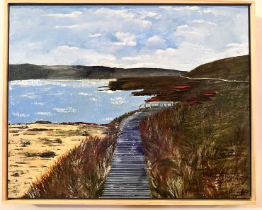 A wooden boardwalk leading to a lake with mountains.
