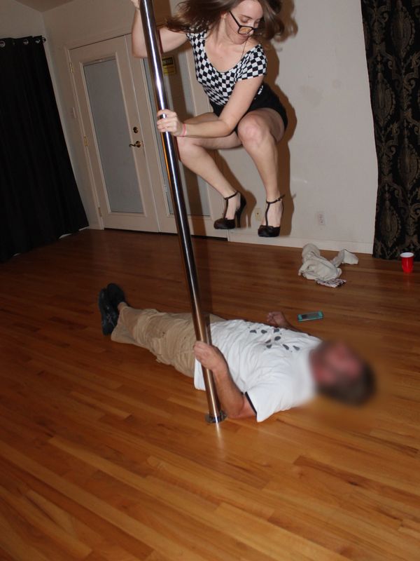 Color photo of  a caucasian non-binary human mid air jumping on a man's chest wearing black high hee