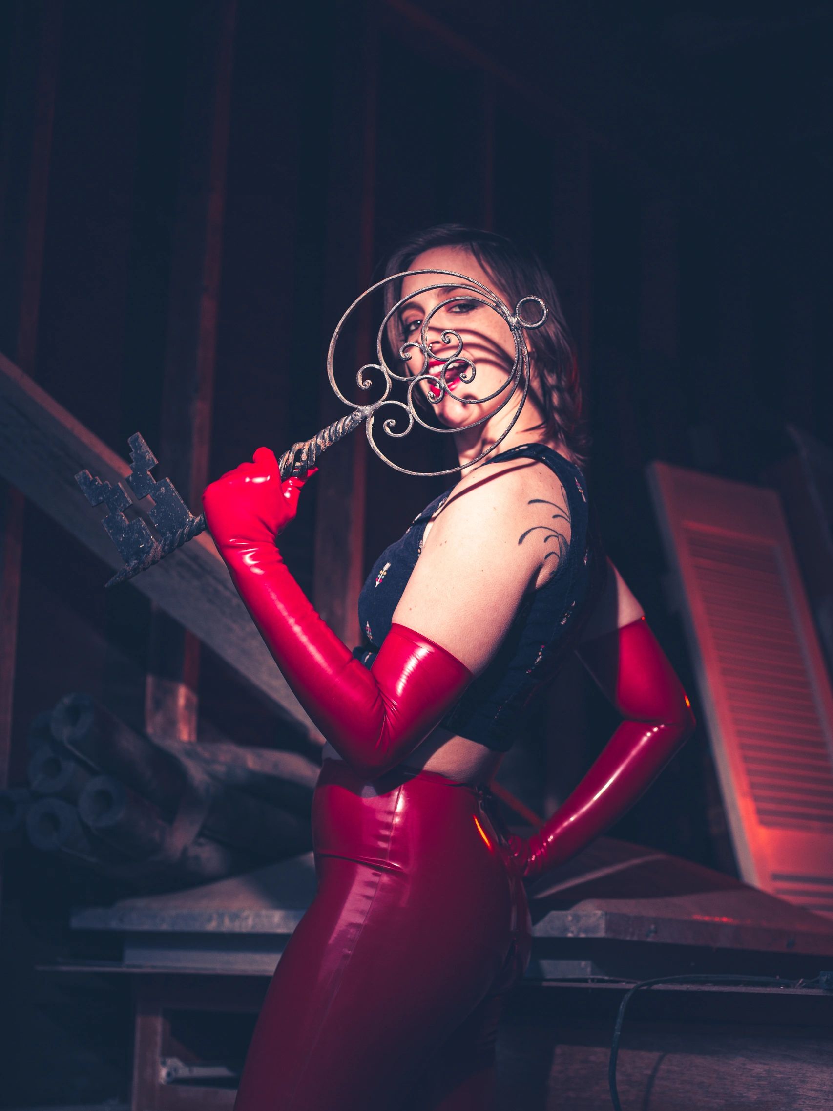 Woman in red gloves holding an ornate giant key.