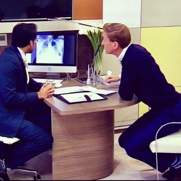 Two men reviewing an X-ray on a computer screen in an office.