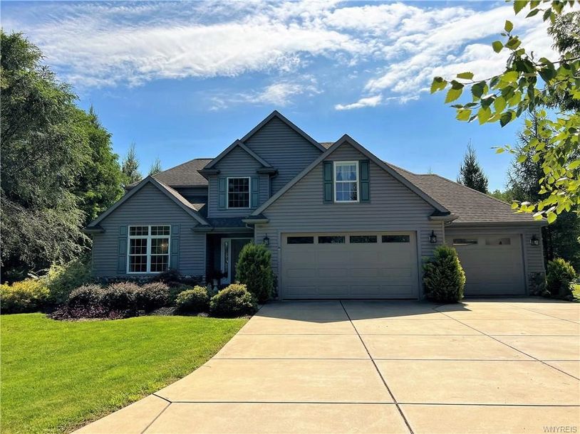 Modern suburban house with gray siding and a spacious driveway.