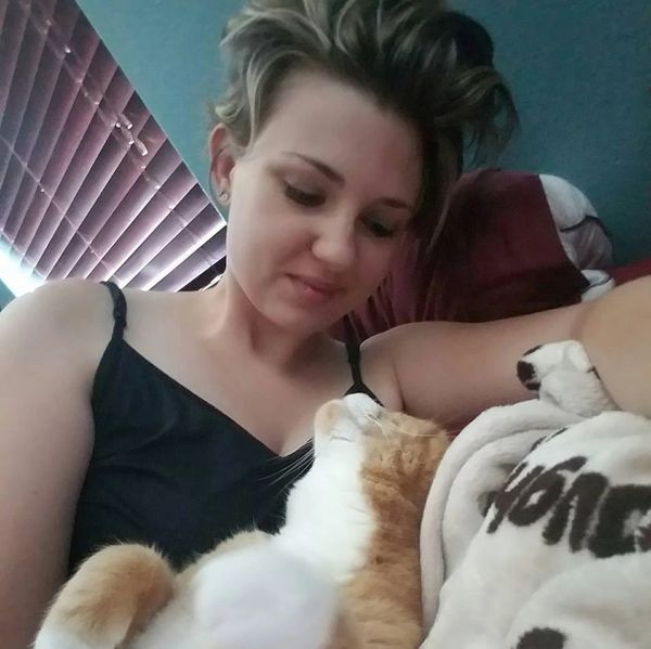 Anissa Jade and her orange cat Charlie snuggled up together