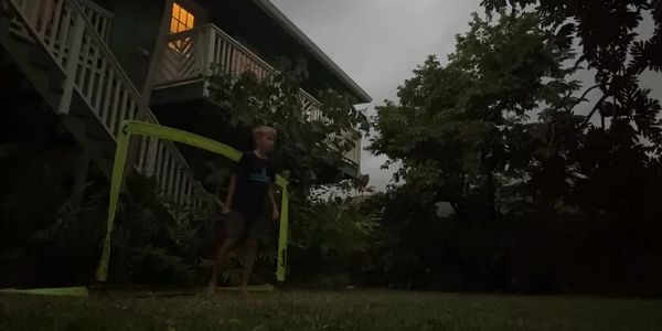Child playing soccer outdoors at dusk.