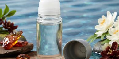 A small bottle of clear liquid with flowers and amber pieces.