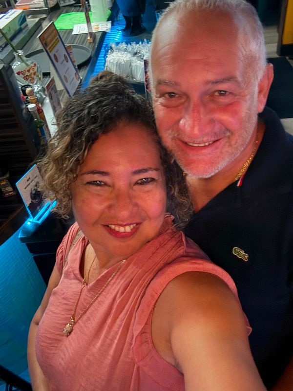 Smiling couple takes a selfie indoors.