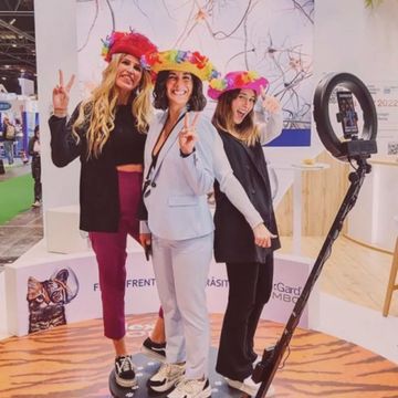 Group of three women with hats on 360 degree selfie machine booth