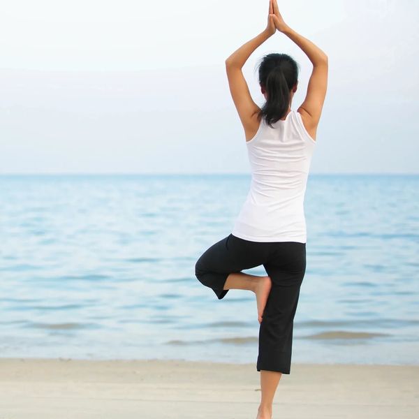 woman doing yoga pose looking at the sea