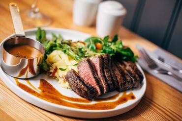 Plated steak, mashed potatoes and peppered sauce