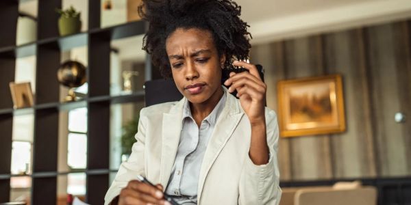 Woman in a beige blazer concentrating on paperwork.