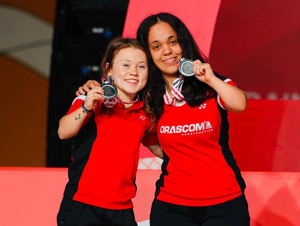 Two female athletes proudly display their silver medals.