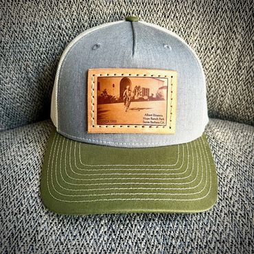 Albert Einstein riding bicycle in Hope Ranch leather patch trucker hat
