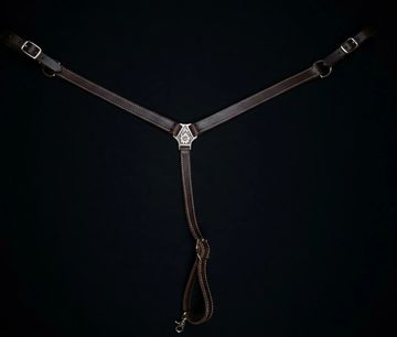 Brown leather strap with metal buckles on black background.