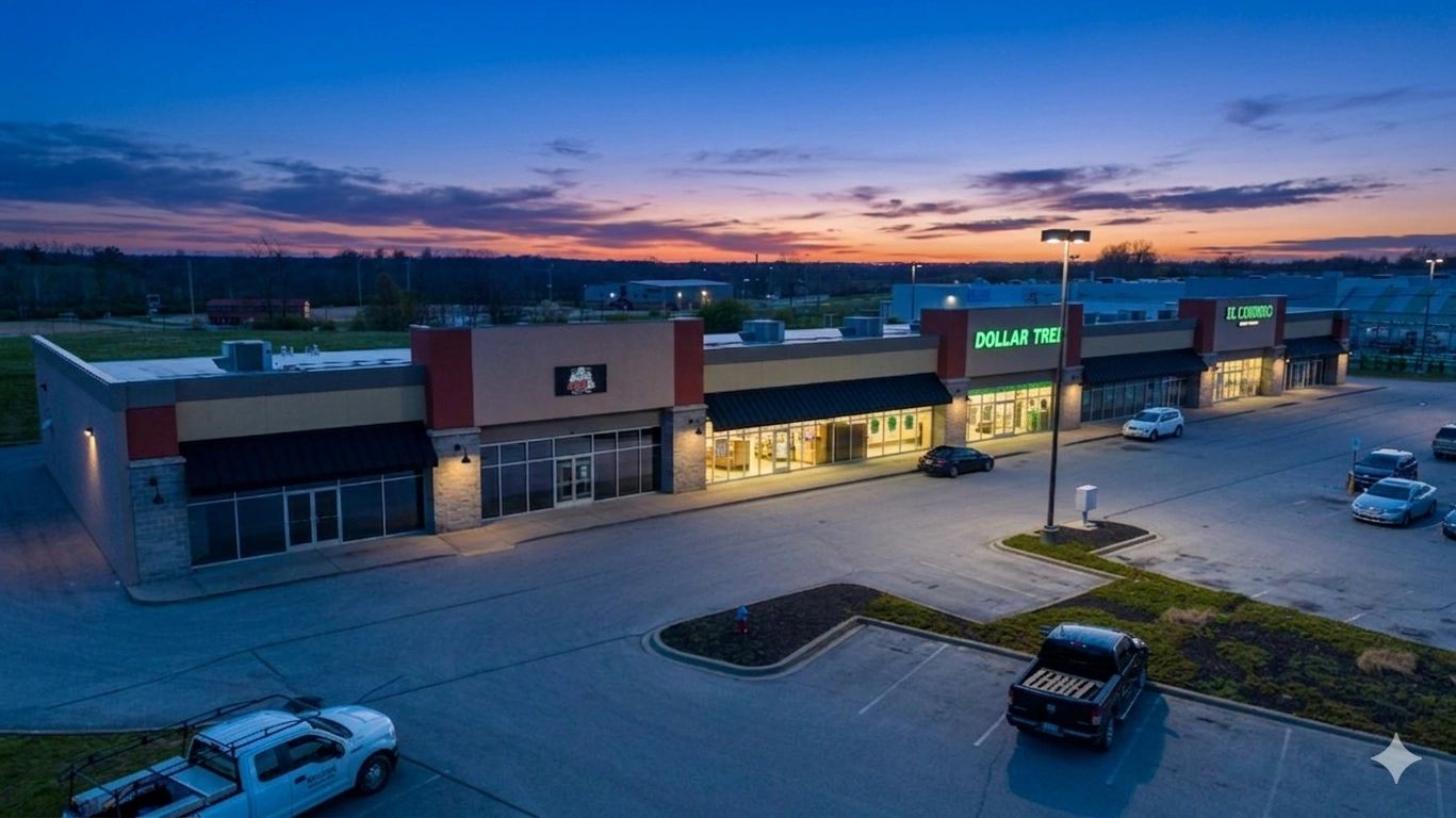 Shopping center at dusk with a few cars parked.