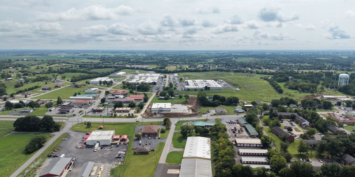 Aerial view of a small town with buildings and green fields.