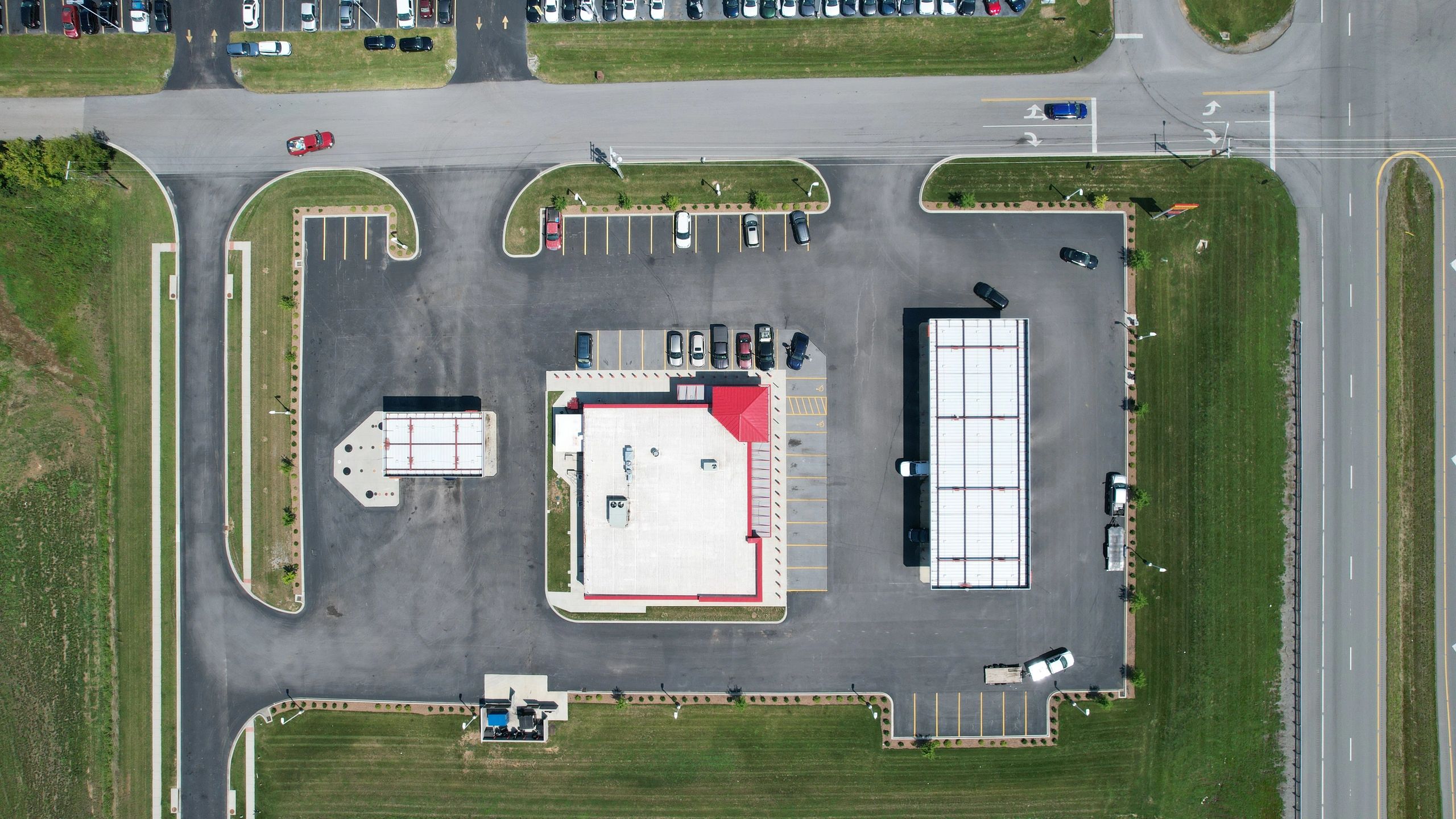 Aerial view of a commercial building with parking and roads.