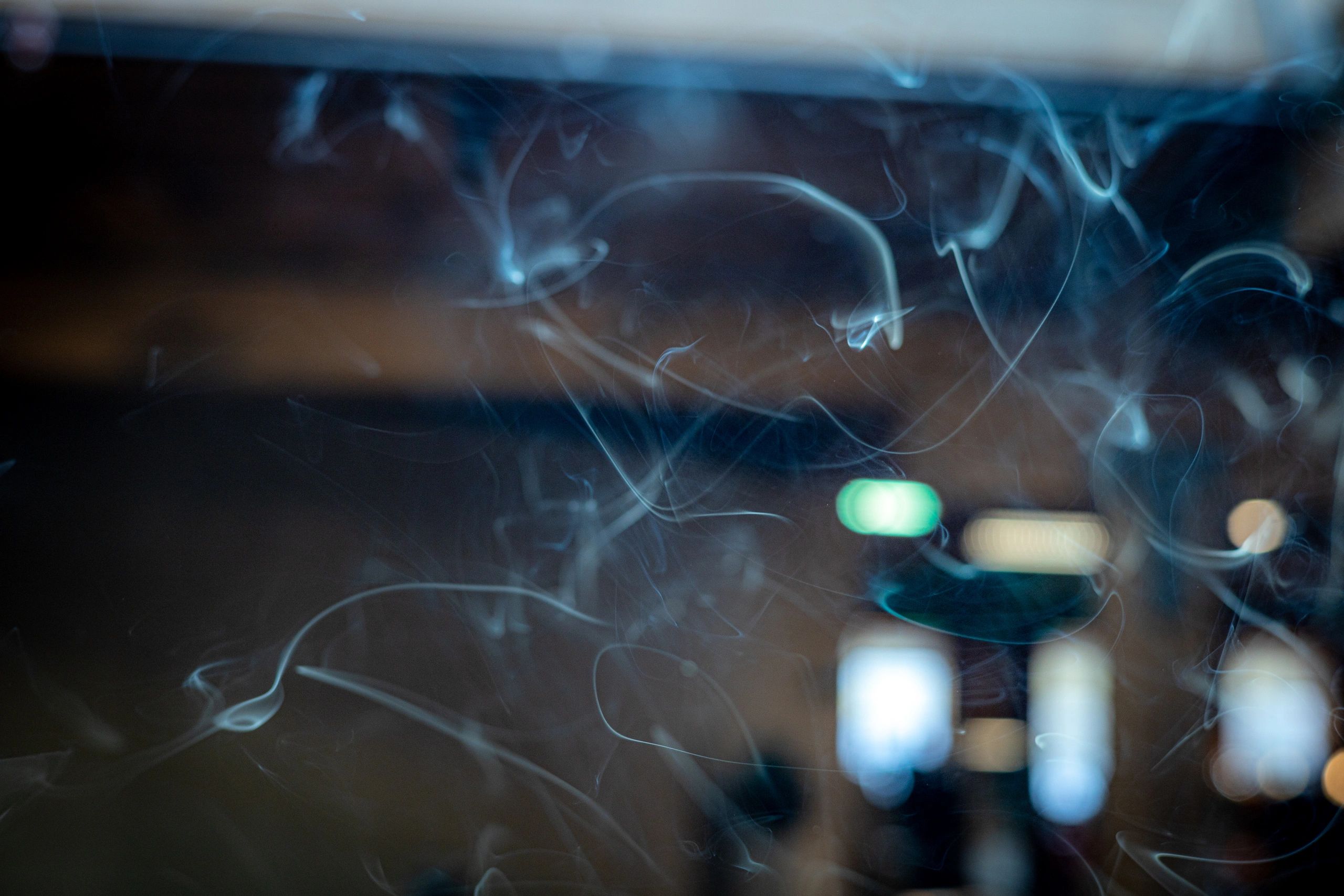 Incense smoke rises near a blurry doorway.