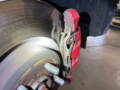 The Front Brake Rotor, Thin Brake Pad and Caliper during a Brake inspection 