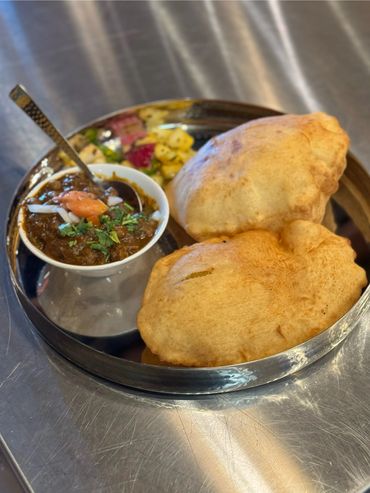 Indian lunch spread: biryani, curry, and naan bread in bowls

