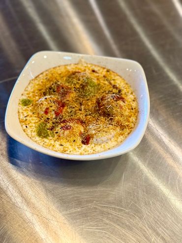 Puffed rice bhel puri snack in a white bowl, tangy and crunchy.


