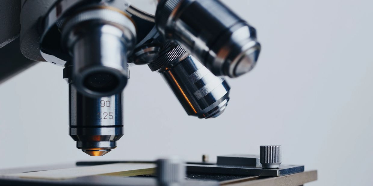 Microscope analyzing sample slide during professional lab testing process