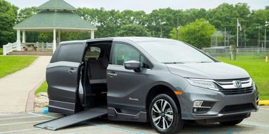 A grey minivan with an electric slide out ramp.
