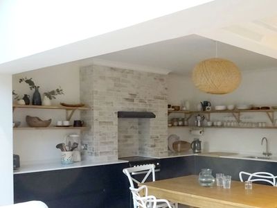 Modern kitchen with minimalist decor and wooden dining table.