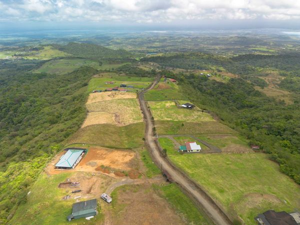 Aerial view of a rural landscape with scattered buildings and green fields.