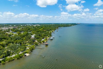 Aerial view of a waterfront residential area with docks and boats under a blue sky.
