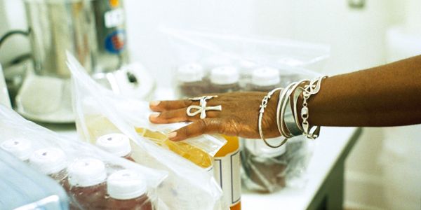 Apryl's hand grazing over bagged bottles of juice, preparing an order. 