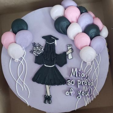 Graduation cake for Mia with balloons and graduate figure.
