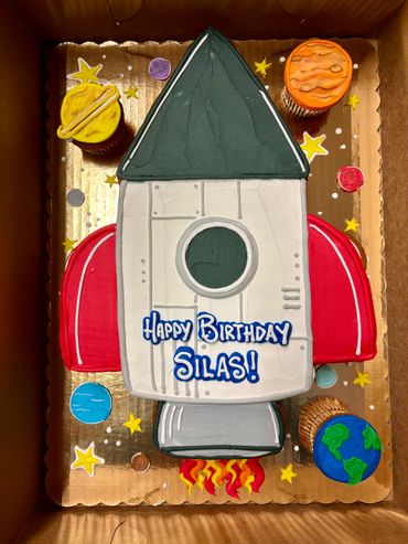 Rocket-themed birthday cake with planets and stars for Silas.