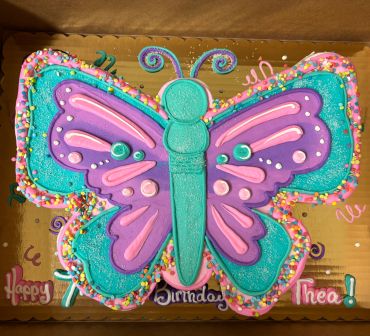 Colorful butterfly-shaped birthday cake with sprinkles.