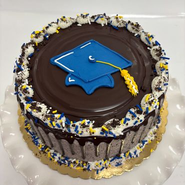Chocolate graduation cake with blue cap decoration.