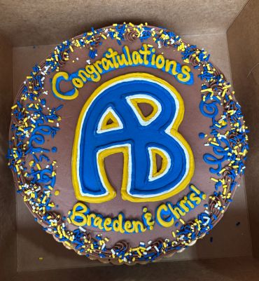 A decorated congratulatory cake with initials AB.
