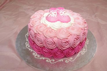 A rose flower cake with shoes on it 