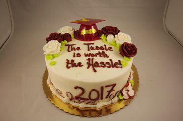 A white colored graduation cake with graduation hat 