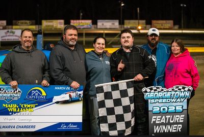 alt="Kwik Motorsports team posing together at the racetrack"