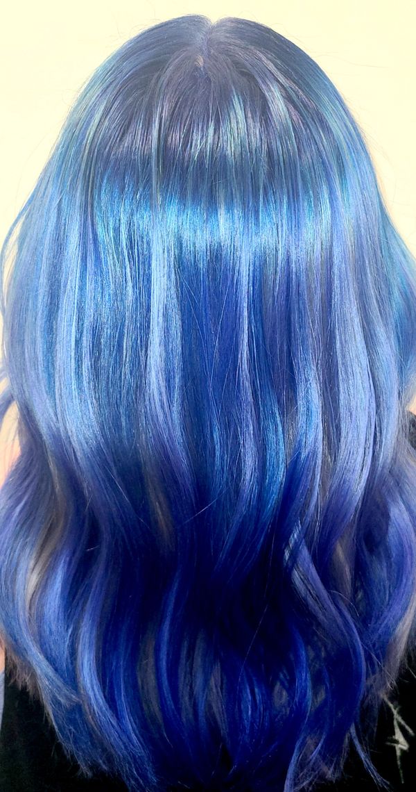 Electric blue hair with pale blue highlights shown from the back at Peachtree City salon