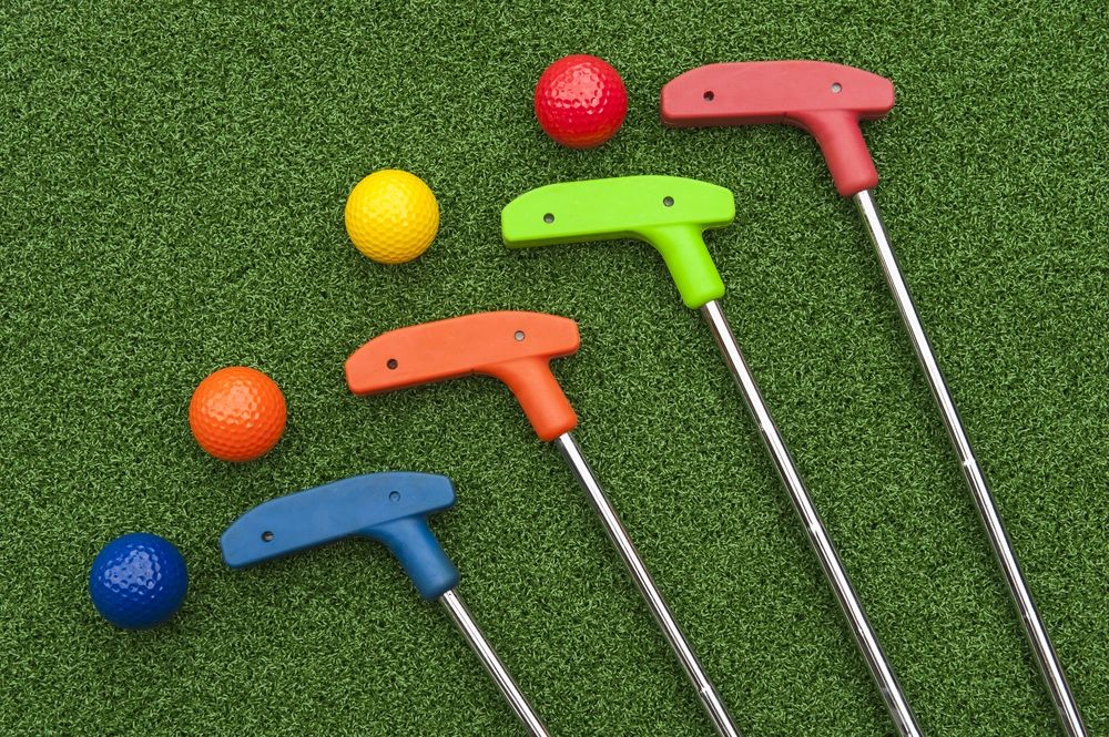 Colorful miniature golf clubs and balls