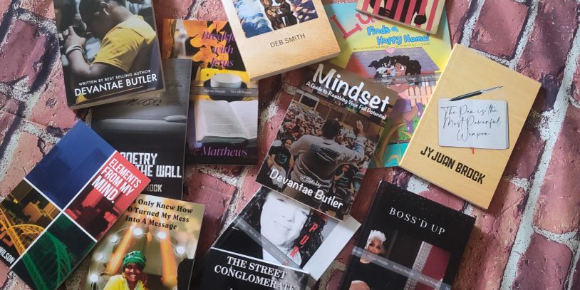 Collection of books and booklets spread on a brick floor.