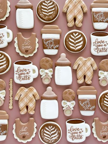 Assorted baby-themed and coffee-inspired decorated cookies in neutral tones.