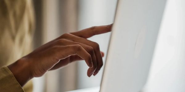 Person touching a laptop screen.