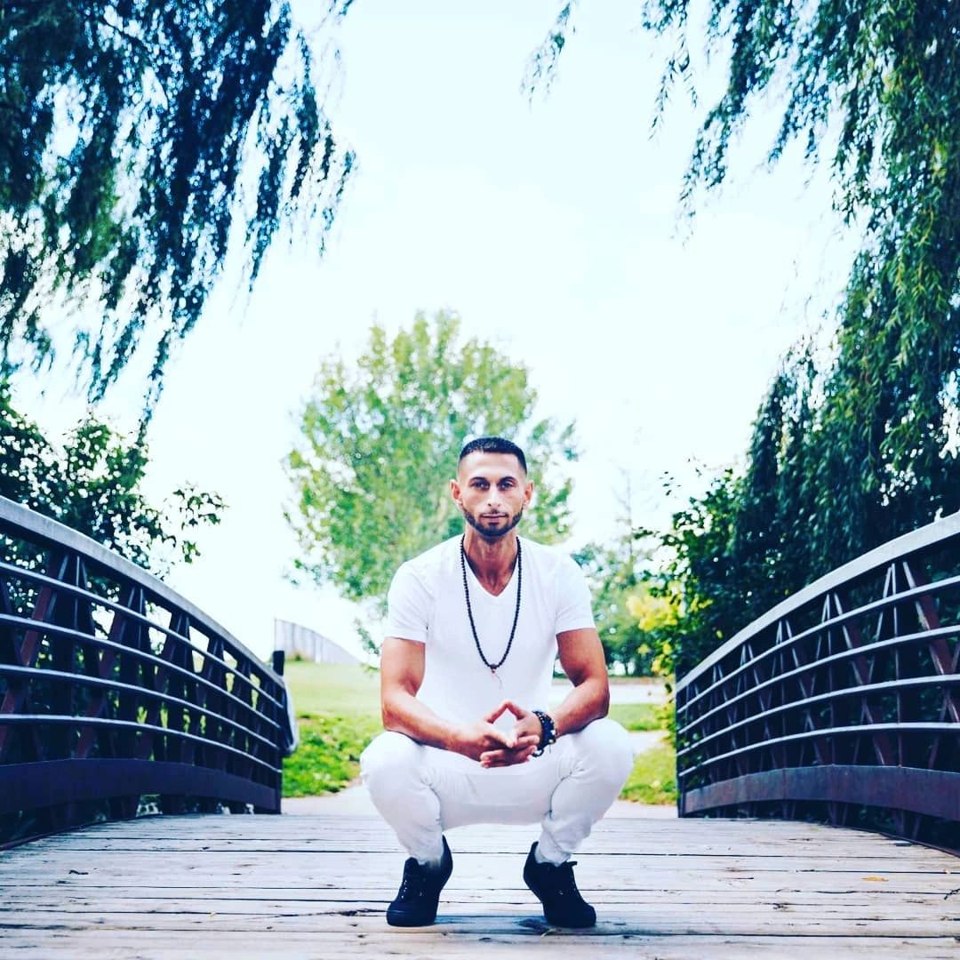 Practitioner of Reiki in Mississauga dressed in white posing on a bridge